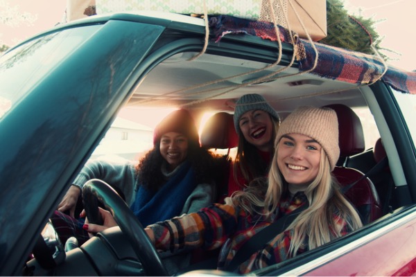 Friends in a car looking at camera